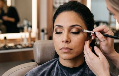 Maquiadora aplicando sombra nos olhos de uma cliente
